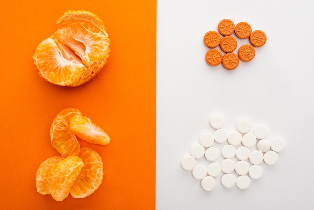 Top View of Dietary Supplements And Mandarin on White And Orange