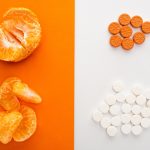 Top View of Dietary Supplements And Mandarin on White And Orange